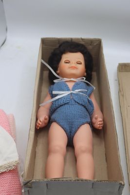deux poupées posées dans une boîte sur une table