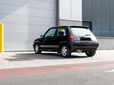 a small black car parked in front of a building