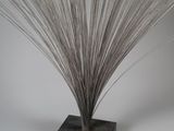 sculpture of a metal plant on a wooden base on a white background