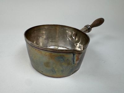 a metal bowl with a wooden handle on a white surface