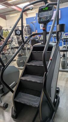 an image of a group of people in a gym with tread machines