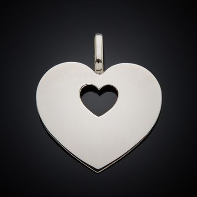 a silver heart shaped pendant with a hole in the middle
