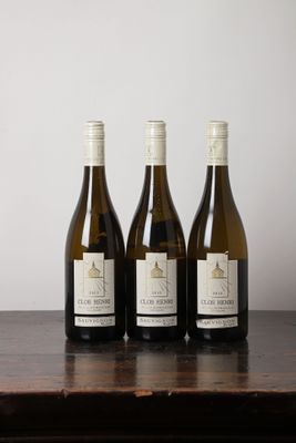 trois bouteilles de vin posées sur une table en bois