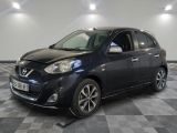 La Nissan Mico noire est garée dans une pièce au sol carrelé en damier.
