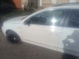 une voiture blanche garée sur un parking, dont la portière est ouverte