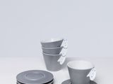 un service de trois tasses et soucoupes posé sur une table blanche