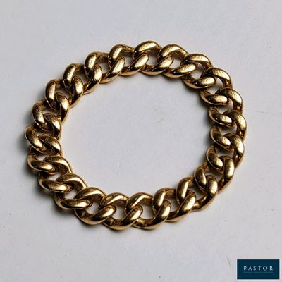 gros plan d'un bracelet en chaîne en or sur une surface blanche