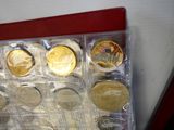 une photo d'une boîte remplie de pièces d'or et d'argent
