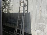 une échelle appuyée contre un mur, à côté d'un immeuble