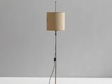 un lampadaire noir surmonté d'un abat-jour beige