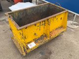 a yellow dumpster sitting in front of a blue wall