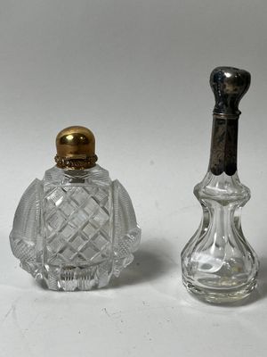 deux petites bouteilles en verre avec un bouchon doré et une bouteille en verre avec un bouchon noir