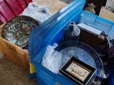 une boîte bleue remplie d'objets, posée par terre