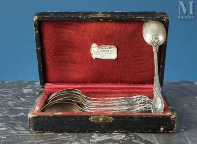 une cuillère en argent et une cuillère dans un étui posé sur une table