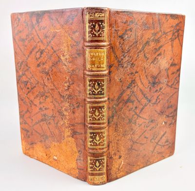 un vieux livre aux tranches dorées et à la couverture marron