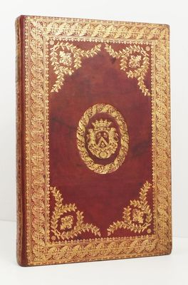un vieux livre rouge avec des motifs dorés sur la couverture