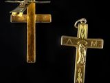 two gold crosses are shown against a black background