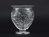 a clear glass vase with a lid on a black background