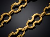 a close up of a gold chain on a black background