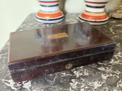 une petite boîte en bois posée sur une table, avec deux vases orange et blancs