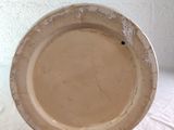 a brown plate on a table with a white background