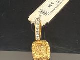 un petit pendentif en or auquel est attachée une étiquette