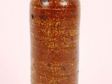 a brown vase that is sitting on a white surface