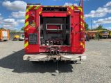 a red fire truck with its door open in a parking lot