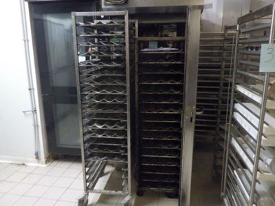 de nombreuses étagères chargées de plateaux de nourriture dans une cuisine