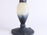 a close up of a black and white vase on a white surface