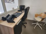 a desk with a computer and a chair in the corner