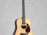 un gros plan d'une guitare acoustique sur fond gris