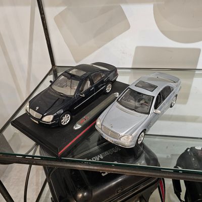 deux petites voitures posées sur une table en verre