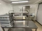 une cuisine équipée d'un évier et d'un plan de travail sur lequel sont posés des paniers