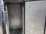 several stainless steel refrigerators are lined up in a warehouse
