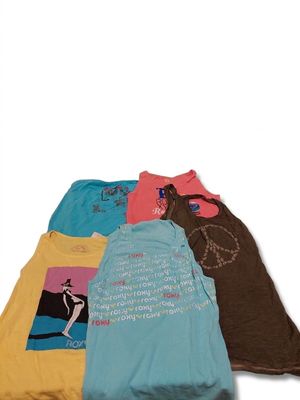 Quatre t-shirts sont alignés en rang sur une surface blanche