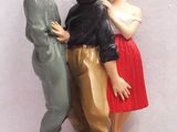 trois figurines représentant un homme et une femme posées sur une table