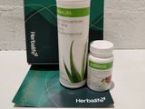 une bouteille d'Herbalife et une boîte de comprimés posées sur une table