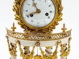 une horloge blanche et or posée sur une table