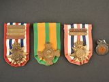 three medals and a medal on a black surface