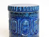 a close up of a blue container on a white surface