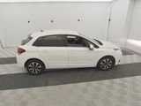 the small white car is parked in a clean room