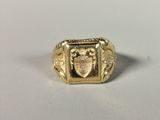 a close up of a gold ring with a crest on it