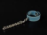 blue leather dog leash with silver ball chain on black background