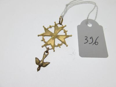 un gros plan d'une croix en or suspendue à un cordon, avec une étiquette de prix