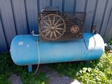 un réservoir bleu muni d'un ventilateur, placé devant un immeuble