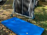 un matelas bleu posé par terre devant une maison