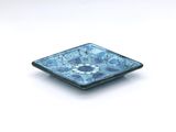 small square blue and white plate with a flower design on it