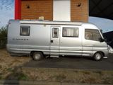 a silver camper van parked in front of a building