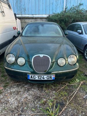 une voiture verte garée à côté d'autres voitures